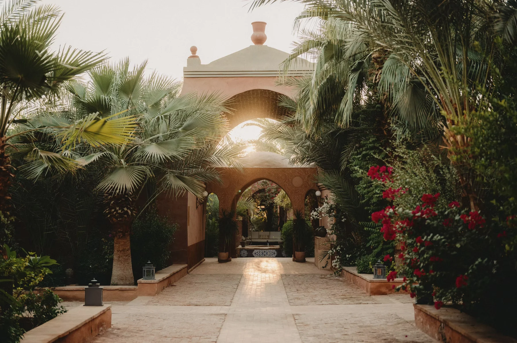 Al Moudira — Al Moudira entrance courtyard, palms and warm evening light