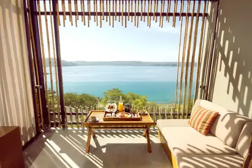 Andaz Peninsula Papagayo — An Andaz Papagayo guestroom balcony with breakfast and bay view