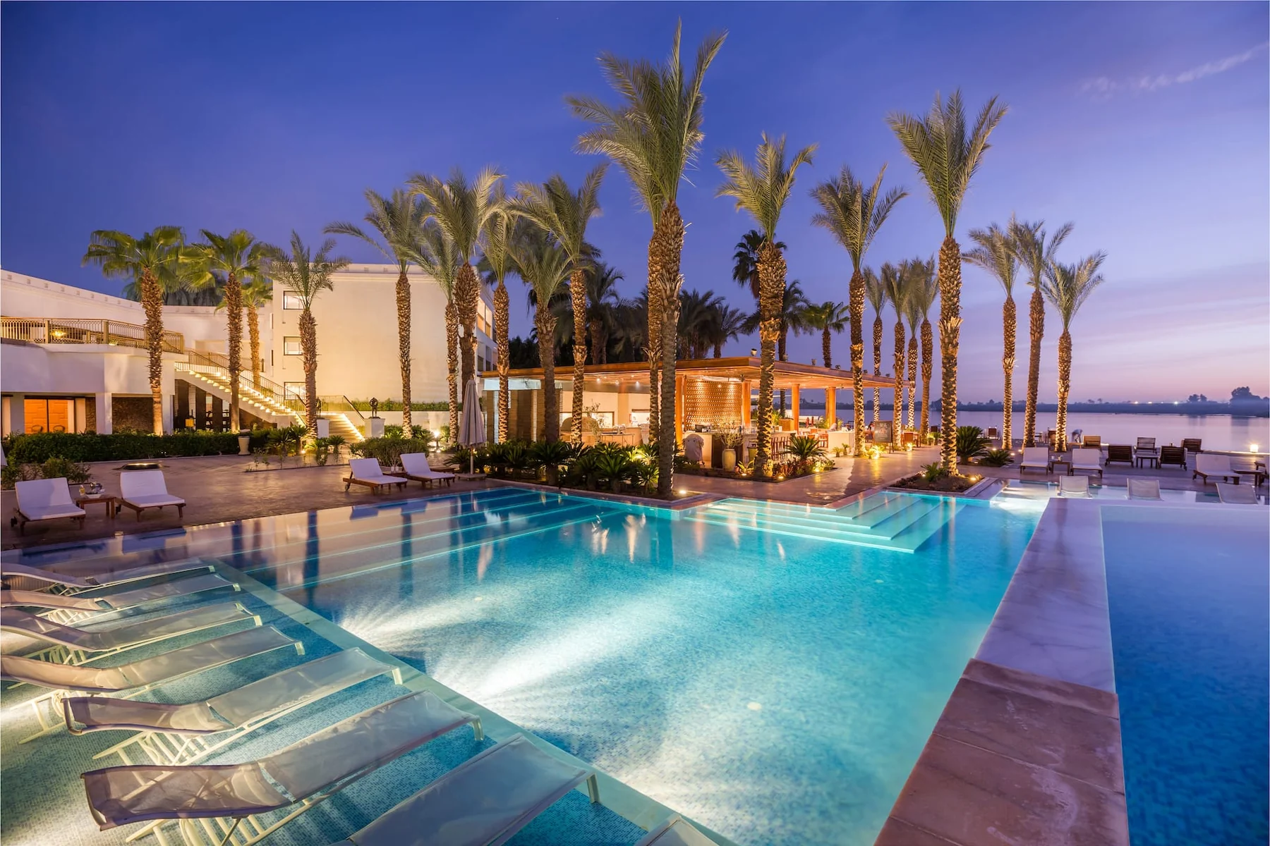 Hilton Luxor — Hilton Luxor’s illuminated pool and Nile-side terrace at dusk