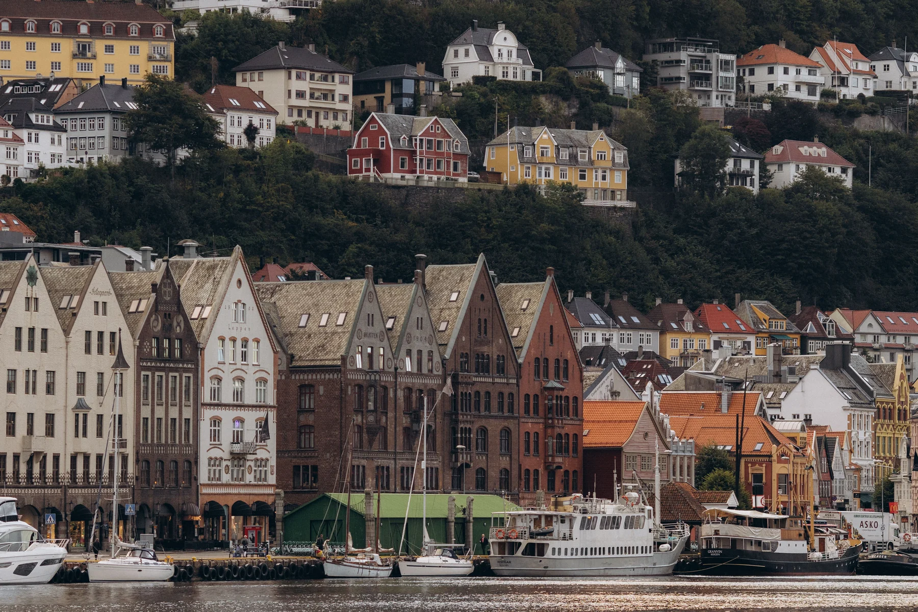 Bergen — colourful Bryggen waterfront and boats beneath the hillside